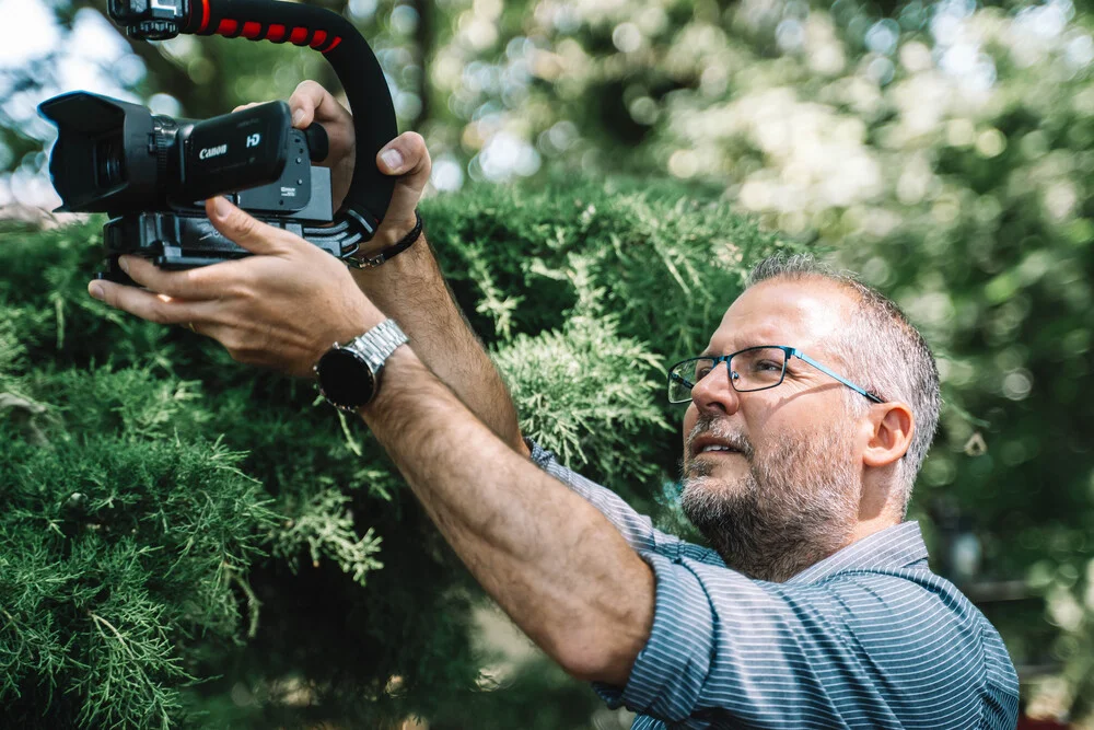 Guillaume Witzer vidéaste dans l'Aube capturé en plein tournage tenant sa caméra professionnel